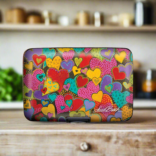 Laurel Burch Dancing Hearts Armored Wallet featuring colorful heart motifs on aluminum exterior with RFID protection and compact design